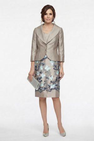 Modelo posando de frente con un conjunto de dos piezas compuesto por vestido midi y chaqueta elegante en tonos neutros.