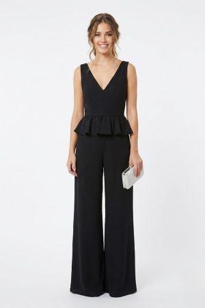 Mujer luciendo un elegante mono largo de fiesta negro con escote en V y volante peplum de frente.