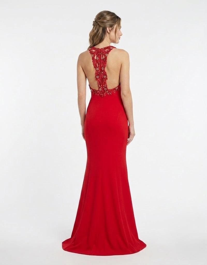 Vista trasera de modelo en vestido de fiesta largo rojo con espalda descubierta y pedrería.