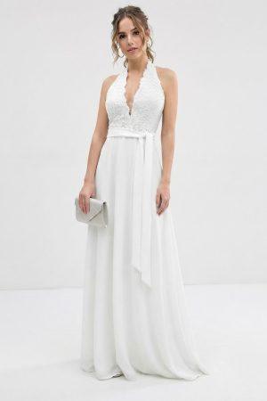 Vista frontal de modelo luciendo un vestido largo blanco de fiesta con cuerpo de encaje, escote halter y lazo en la cintura.