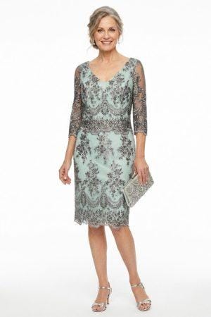 Modelo luciendo un elegante vestido de madrina color verde menta con encaje floral detallado y manga tres cuartos.