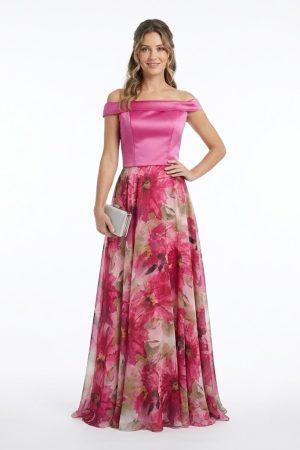 Mujer luciendo un elegante conjunto largo de fiesta con cuerpo fucsia y falda fluida estampada