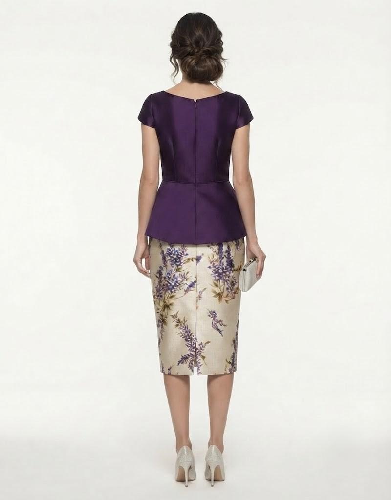 Vista posterior del vestido midi que muestra el ajuste entallado del cuerpo morado y la caída de la falda estampada.