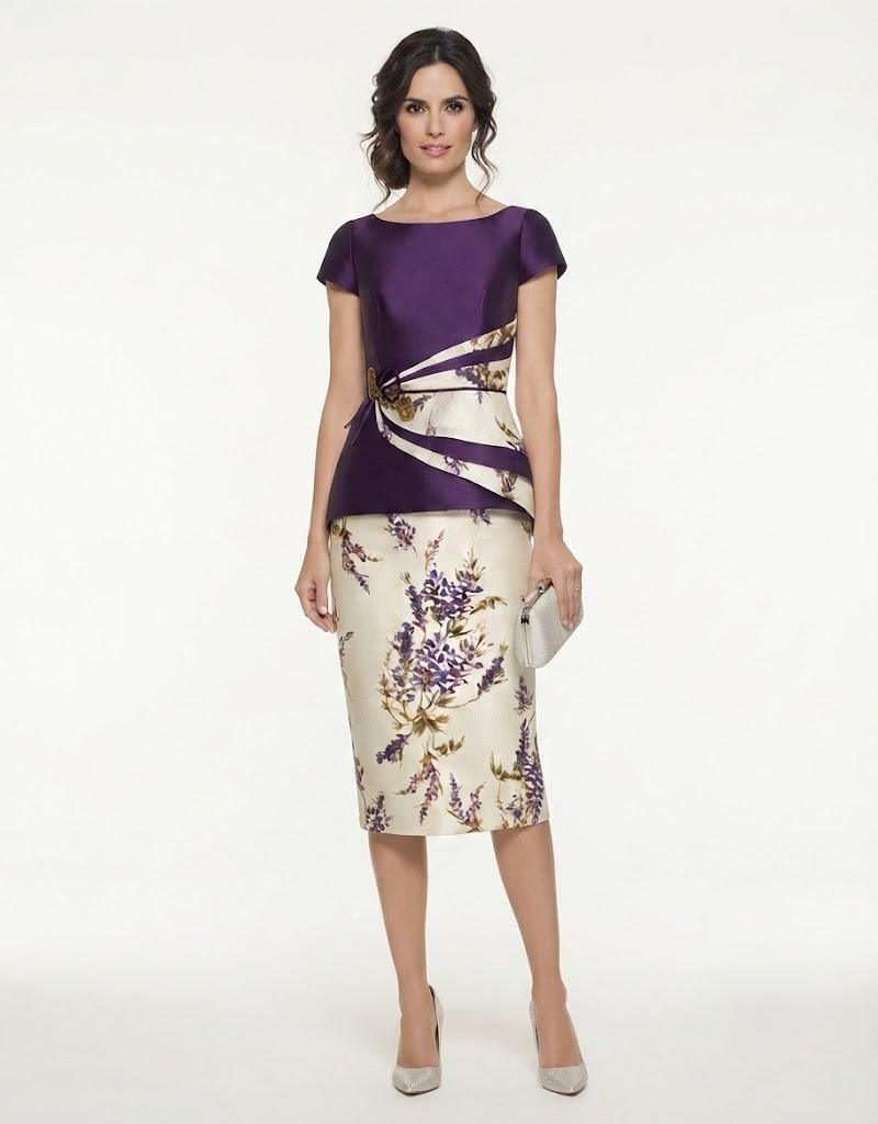 Modelo vistiendo un vestido midi compuesto por cuerpo morado peplum y falda lápiz con estampado floral.
