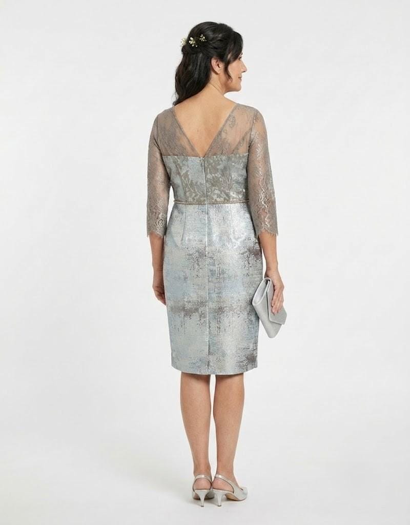Modelo luciendo un conjunto de vestido y chaqueta elegante en tono plateado para madrinas.