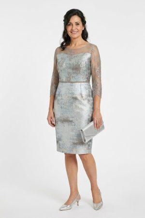 Modelo luciendo un conjunto de vestido y chaqueta elegante en tono plateado para madrinas.