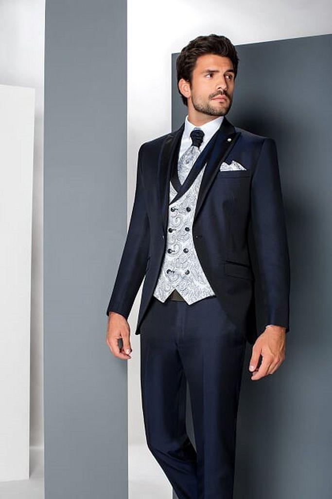 Traje de novio azul marino con chaleco cruzado plateado y corbata de cachemir