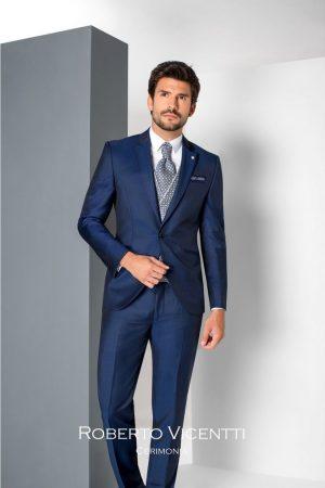 Traje de novio azul tintoretto satinado con chaleco cruzado geométrico y corbata a juego
