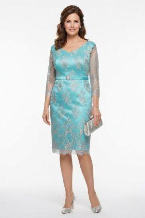 Modelo luciendo un elegante vestido corto turquesa de ceremonia en talla grande con encaje y cinturón de pedrería.