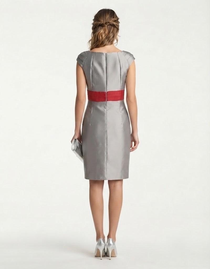 Vista trasera de modelo con vestido gris de ceremonia y detalle de fajín rojo.