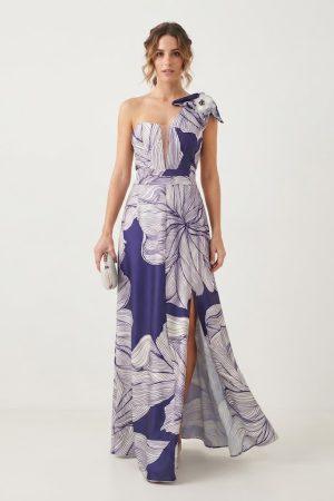 Vista frontal de modelo luciendo un vestido largo estampado de fiesta con un solo hombro, lazo decorativo y abertura en la pierna.