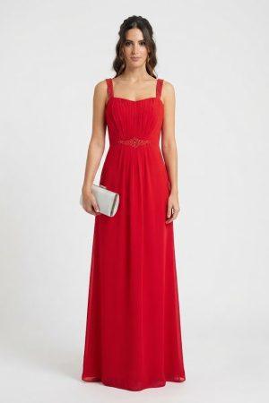 Vista frontal de modelo con vestido largo rojo de fiesta, cuerpo drapeado y detalles de pedrería en tirantes y cintura.