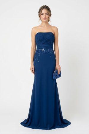 Mujer luciendo un elegante vestido largo de fiesta azul marino con escote palabra de honor y detalles de pedrería