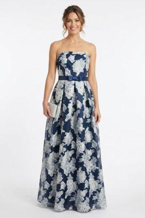 Mujer luciendo un elegante vestido largo de fiesta azul marino con estampado floral y cinturón con lazo