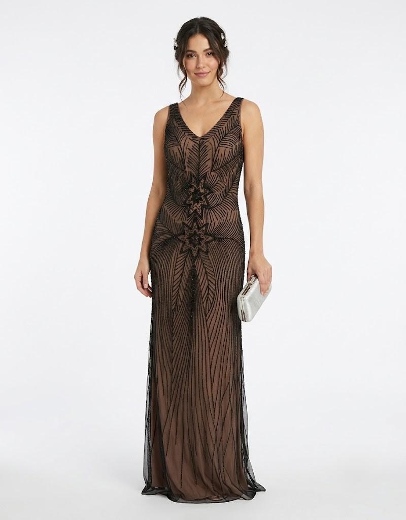 Mujer luciendo un elegante vestido largo de fiesta con abalorios geométricos y escote en V de frente.