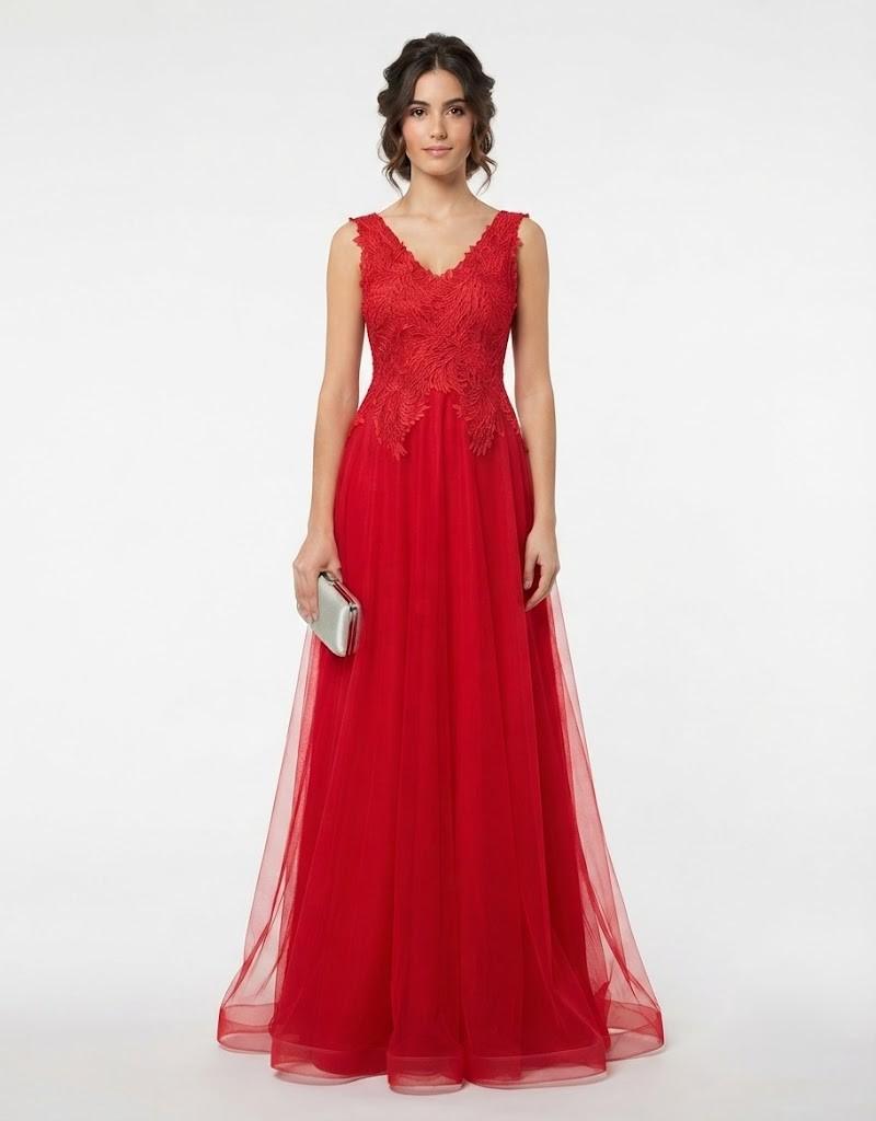 Mujer luciendo un elegante vestido largo de fiesta rojo de tul con cuerpo de encaje de frente.