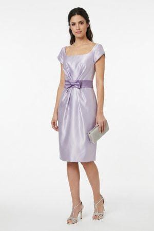 Modelo vistiendo un elegante vestido midi de color lila con escote cuadrado y fajín con lazo.