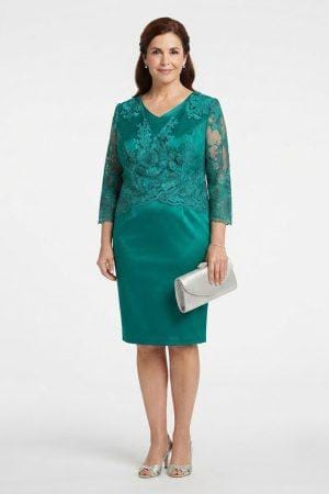 Modelo posando de frente con vestido midi verde esmeralda que combina cuerpo de encaje y falda satinada.
