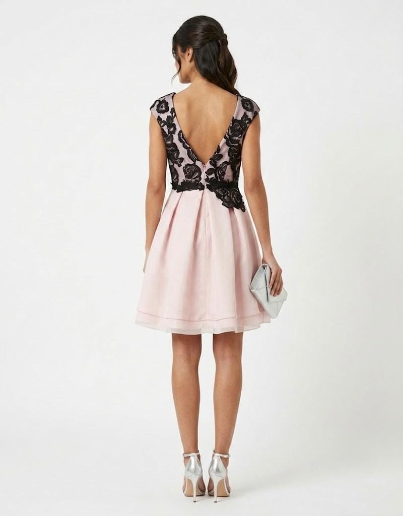 Vista trasera de vestido corto de fiesta rosa y negro, mostrando detalle de espalda en V con encaje.