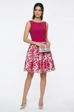 Mujer con vestido corto de fiesta con cuerpo fucsia y falda de flores.