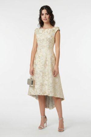Vestido de fiesta midi color dorado con tejido jacquard y corte asimétrico visto desde frente.