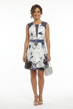 Modelo luciendo vestido de fiesta corto estampado floral con cinturón de terciopelo y detalles de encaje azul.